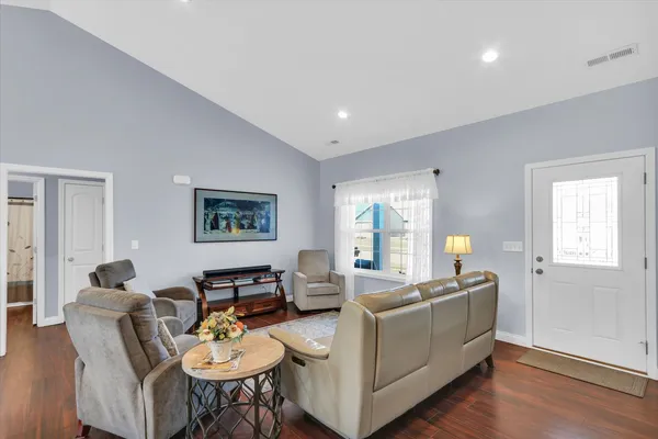 a living room with furniture and wooden floor