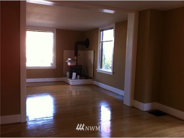 4001 Whitman Avenue North Seattle, WA 98103 - Photo 5 of 8 an empty room with wooden floor and windows