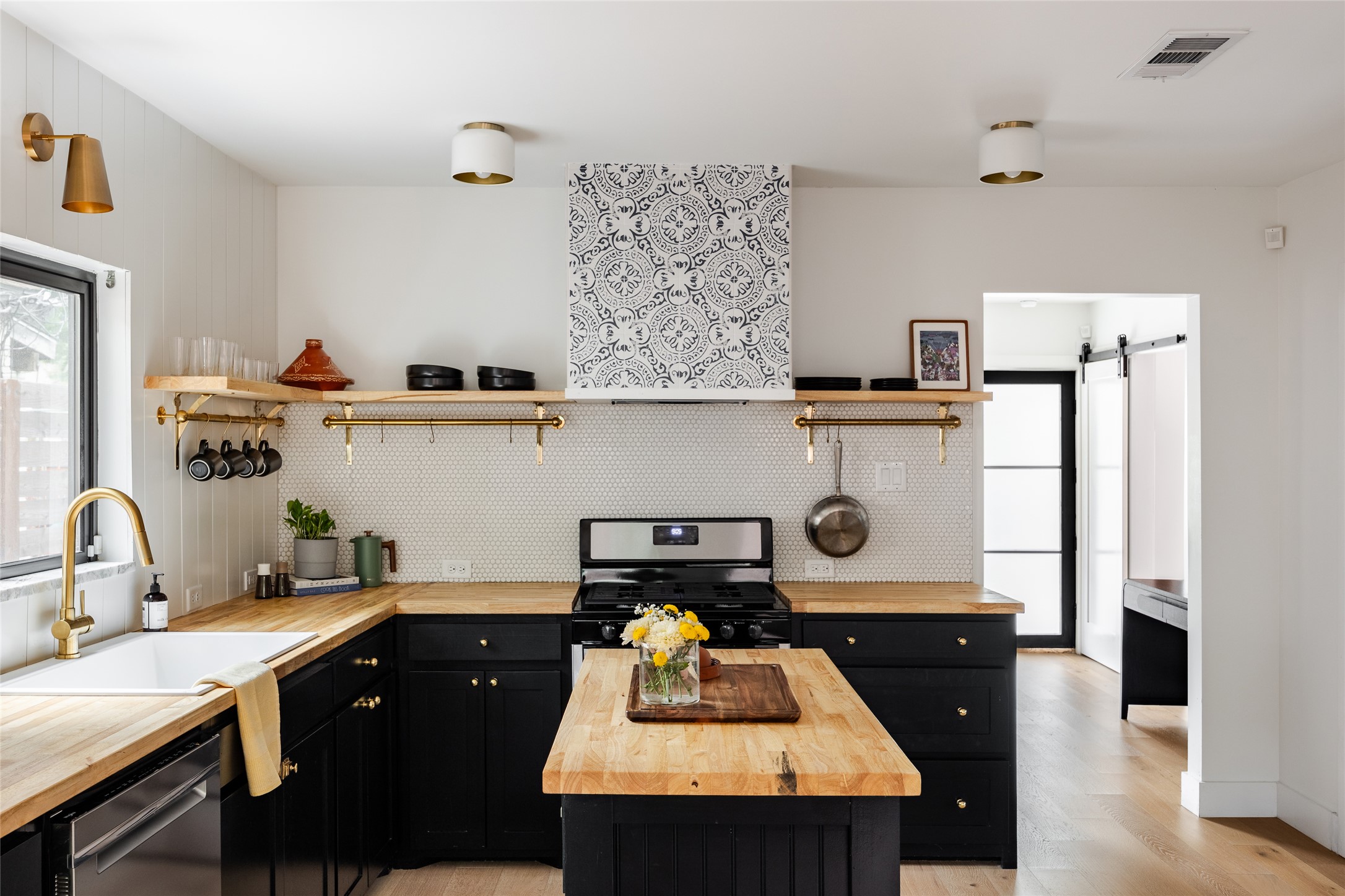 Kitchen with butcher block countertops, plenty of natural light, and dark cabinetry