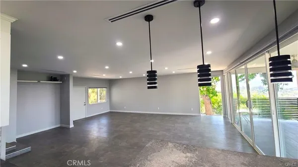 a view of kitchen with stainless steel appliances granite countertop cabinets and a chandelier