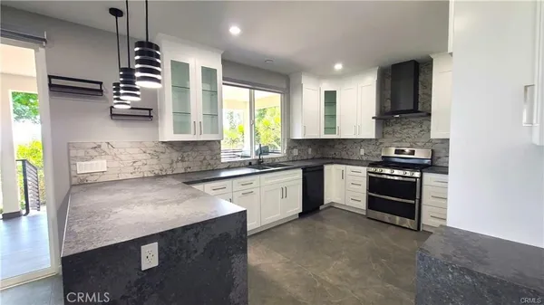a kitchen with stainless steel appliances granite countertop a sink a stove and a refrigerator