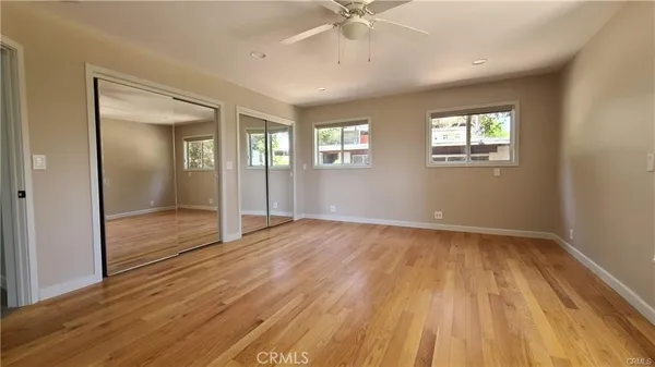 a bathroom with a bathtub shower sink mirror and toilet