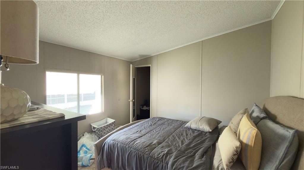 207 Riverwood Road Naples, FL 34114 - Photo 12 of 13 a bedroom with a bed and wooden floor