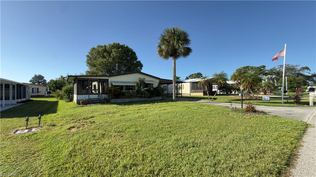 207 Riverwood Road Naples, FL 34114 - Photo 2 of 13 a front view of a house with a yard and a fountain