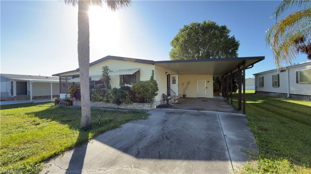 207 Riverwood Road Naples, FL 34114 - Photo 3 of 13 a front view of a house with garden