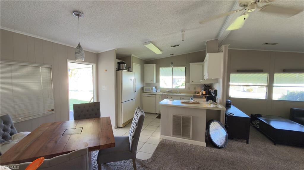 207 Riverwood Road Naples, FL 34114 - Photo 9 of 13 a kitchen with a table chairs refrigerator and cabinets