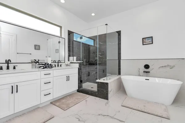 a spacious bathroom with a double vanity sink tub and mirror