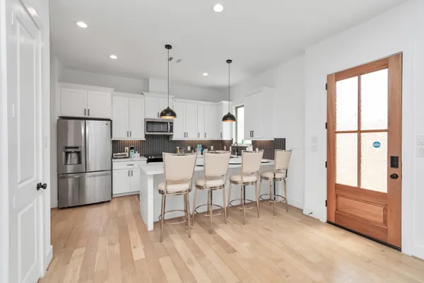 a kitchen with stainless steel appliances kitchen island granite countertop a refrigerator and a stove top oven