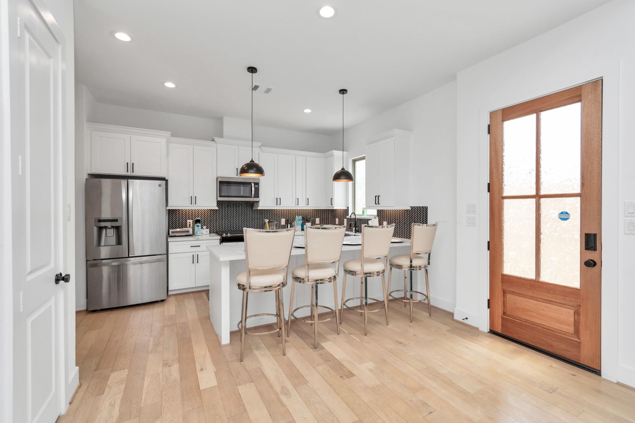 3306 Live Oak Street Houston, TX 77004 - Photo 5 of 10 a kitchen with stainless steel appliances kitchen island granite countertop a refrigerator and a stove top oven