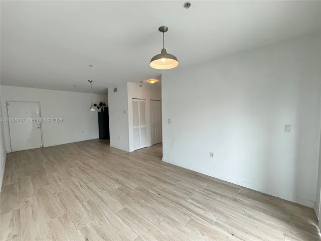 a view of a room with wooden floor and white walls