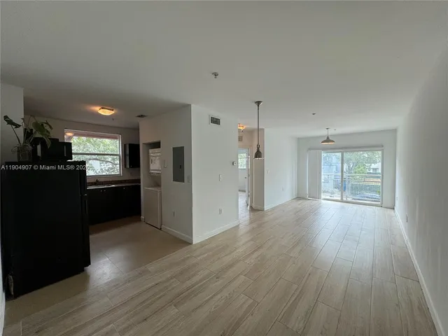 a view of a kitchen with refrigerator and wooden floor