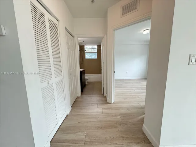 a view of a hallway with a wooden door