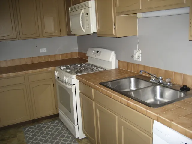 a kitchen with sink a stove and cabinets