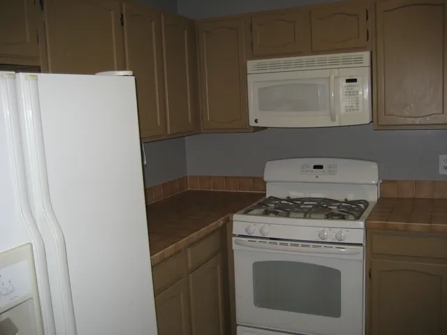 a stove top oven sitting inside of a kitchen