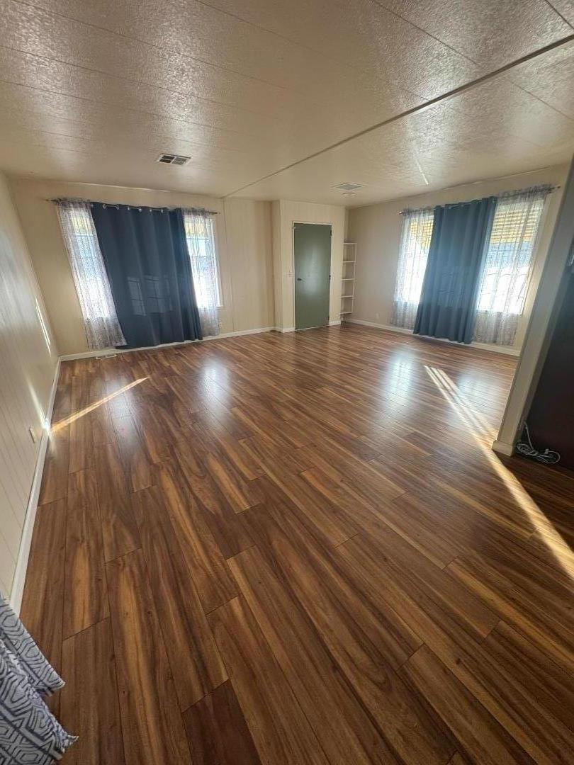 55 San Juan Grade Road, Unit 18 Salinas, CA 93906 - Photo 2 of 6 a view of an empty room with wooden floor and a window