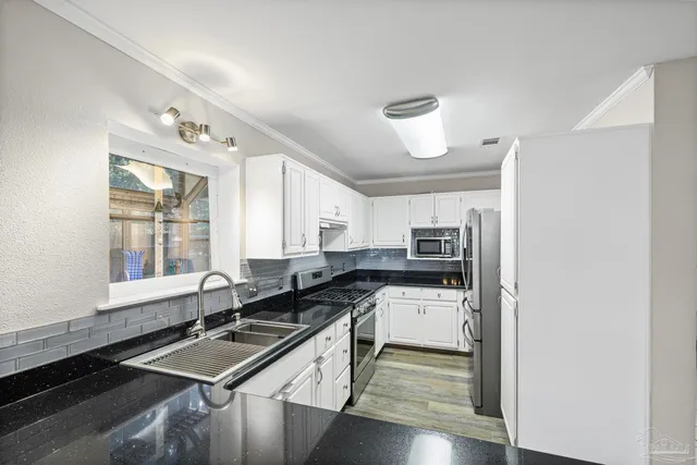 a kitchen with stainless steel appliances granite countertop a sink stove and refrigerator