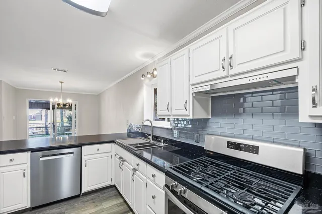 a kitchen with stainless steel appliances granite countertop a sink stove and cabinets