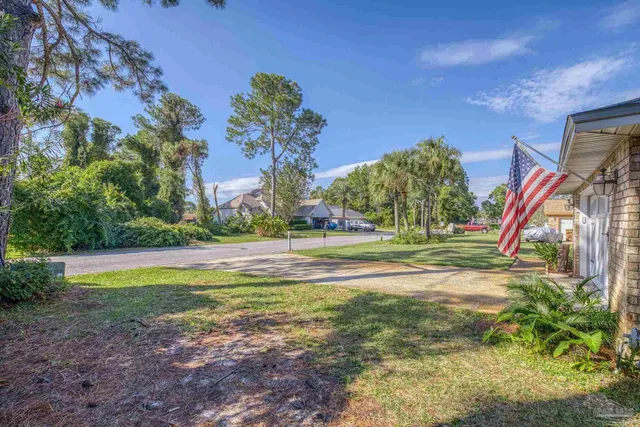 a view of swimming pool with lawn chairs and plants