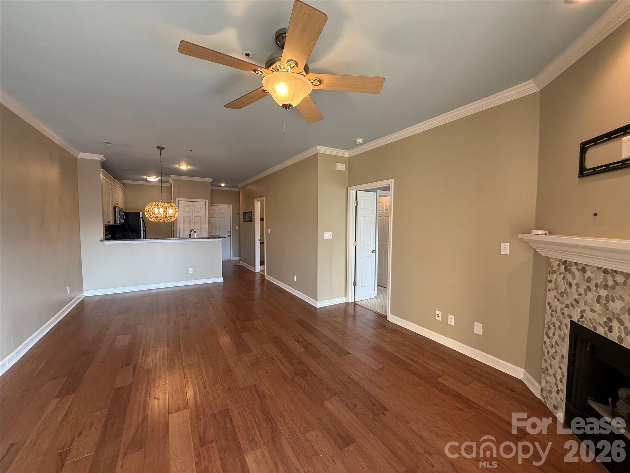 18009 Kings Point Drive, Unit M Cornelius, NC 28031 - Photo 15 of 34 a view of a livingroom with a fireplace a ceiling fan and wooden floor