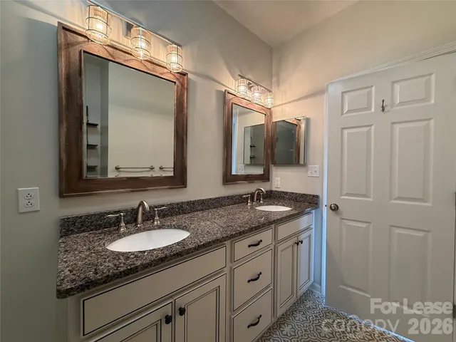 a bathroom with a granite countertop sink double and mirror
