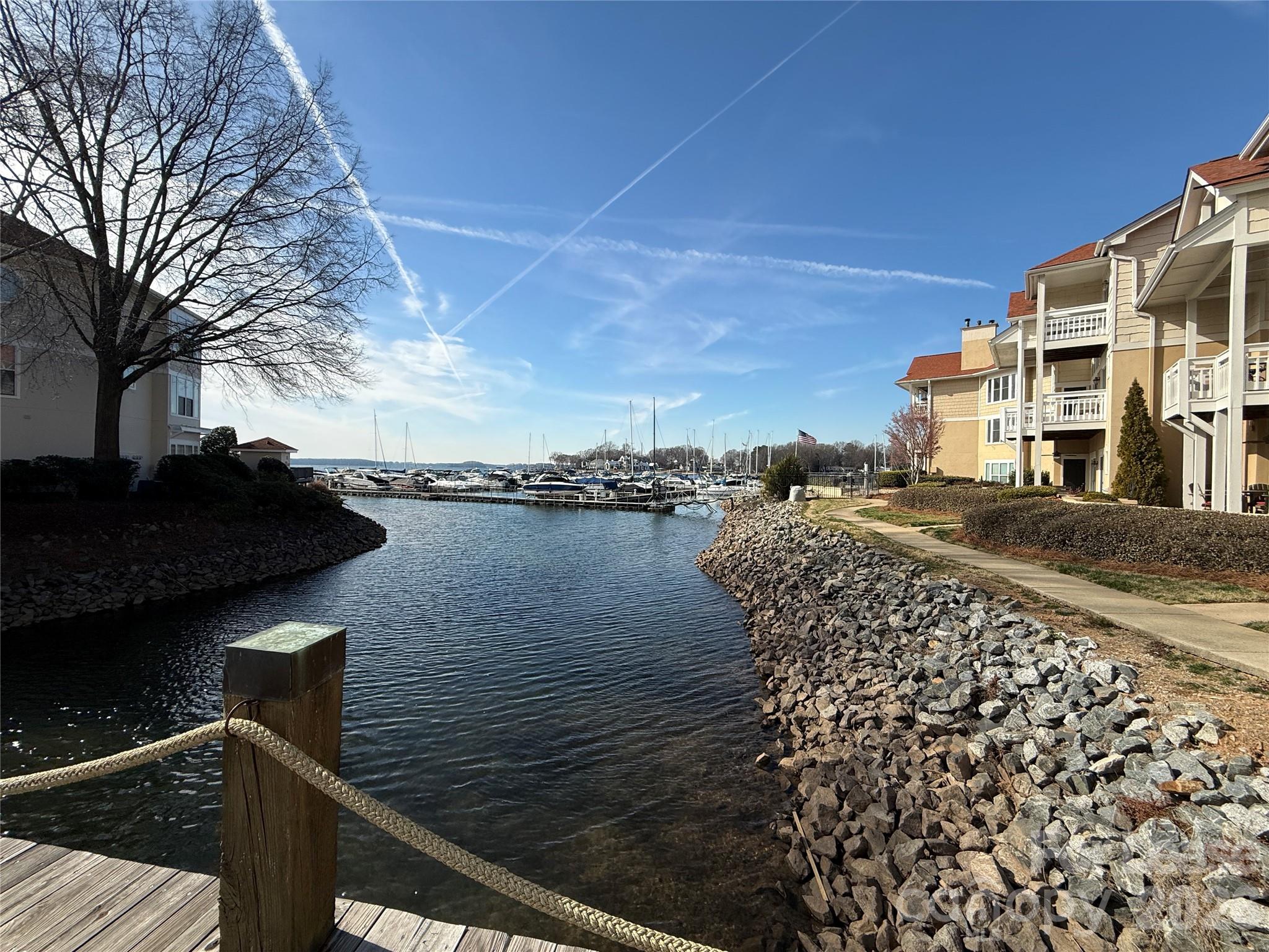 18009 Kings Point Drive, Unit M Cornelius, NC 28031 - Photo 30 of 34 a view of a lake with a building in the background