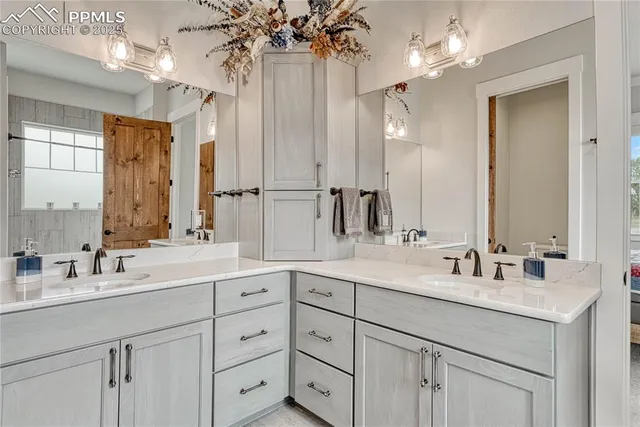 a bathroom with double vanity sinks a vanity a lamp and a mirror