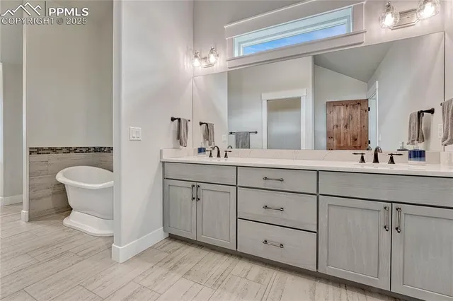 a bathroom with a double vanity sink a mirror and a bathtub