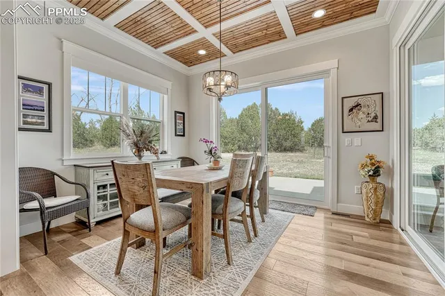 a dining room with furniture a chandelier and wooden floor