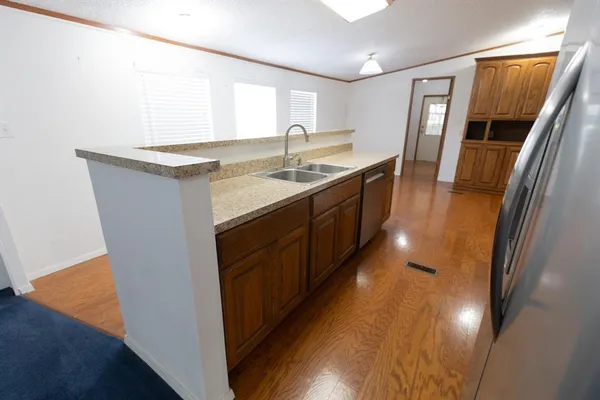 a kitchen with granite countertop a sink stove and refrigerator