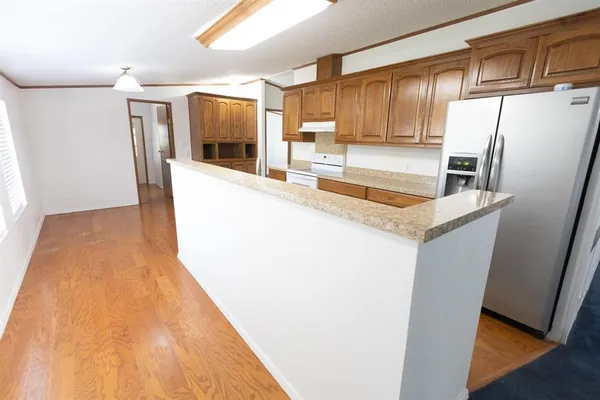 a kitchen with stainless steel appliances granite countertop a refrigerator a sink a stove and island