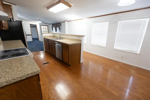 a kitchen with stainless steel appliances granite countertop wooden floors and sink