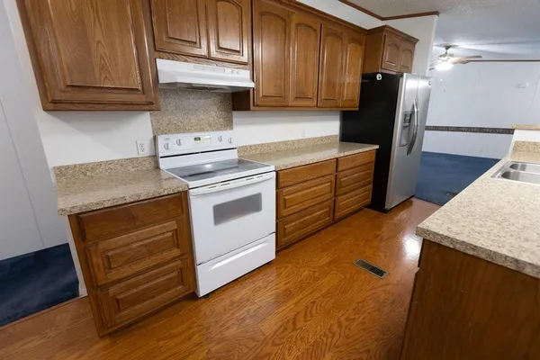 a kitchen with granite countertop wooden cabinets and white appliances