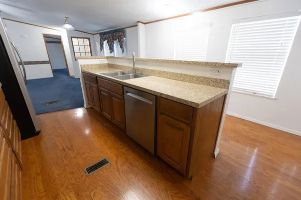 a kitchen with sink cabinets and wooden floor