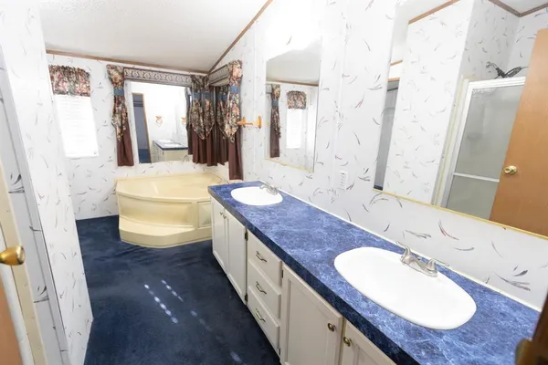 a spacious bathroom with a granite countertop sink and a mirror