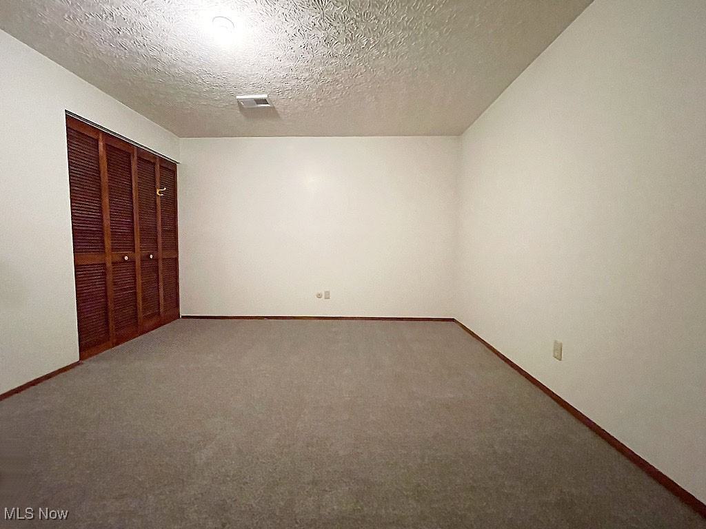 2285 Killian Road Akron, OH 44312 - Photo 13 of 32 Unfurnished bedroom featuring a textured ceiling, carpet flooring, and a closet