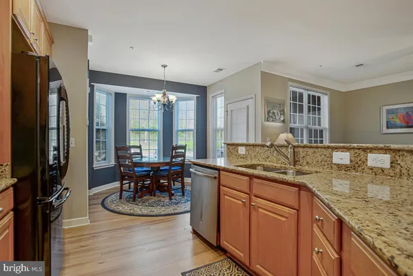 a kitchen with granite countertop cabinets sink and white stainless steel appliances