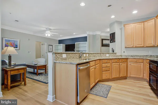 a dining hall with stainless steel appliances granite countertop a stove and a sink