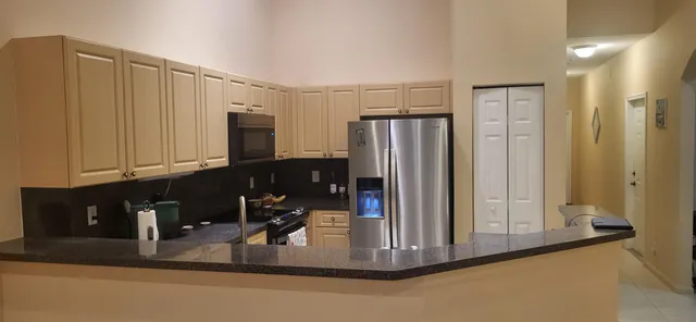 a kitchen with stainless steel appliances granite countertop a refrigerator and a sink