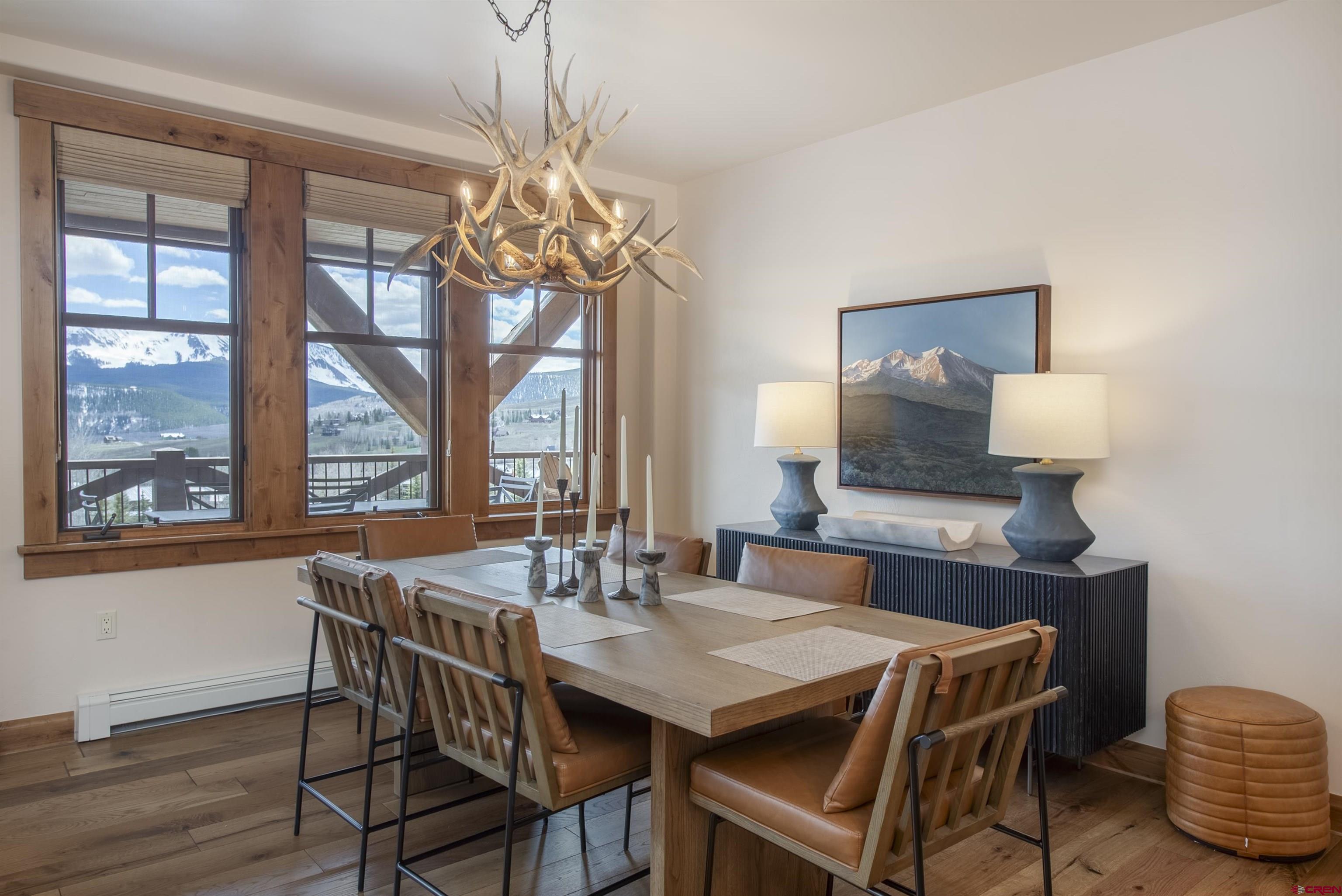 14 Hunter Hill Road, Unit C202 Crested Butte, CO 81225 - Photo 8 of 35 a dining room with furniture a chandelier and wooden floor