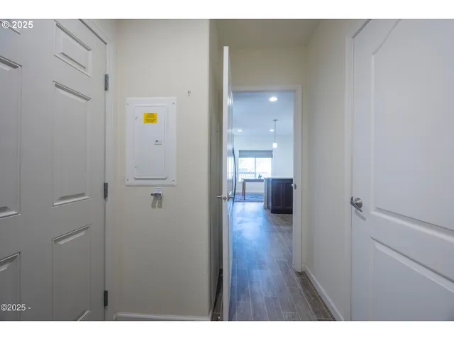 a view of a hallway with wooden floor windows and a bathroom