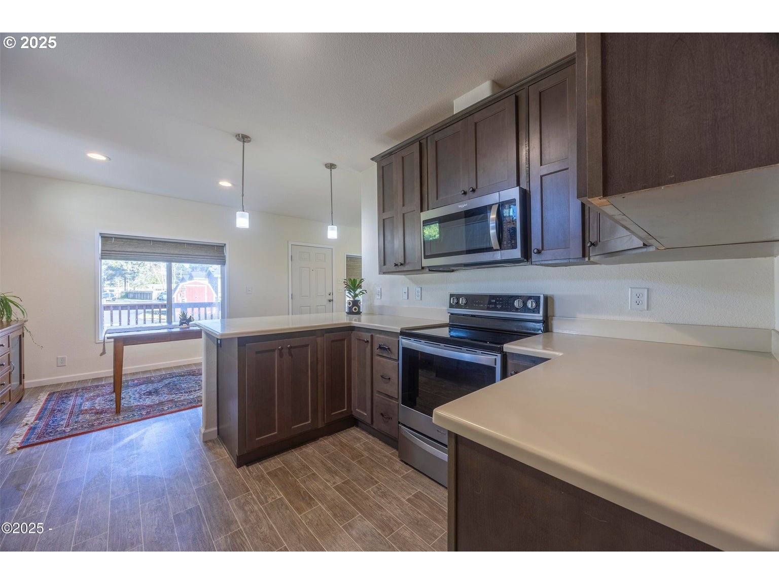 4875 Highway 101, Unit 3 Depoe Bay, OR 97341 - Photo 10 of 26 a kitchen with a sink a microwave and wooden cabinets