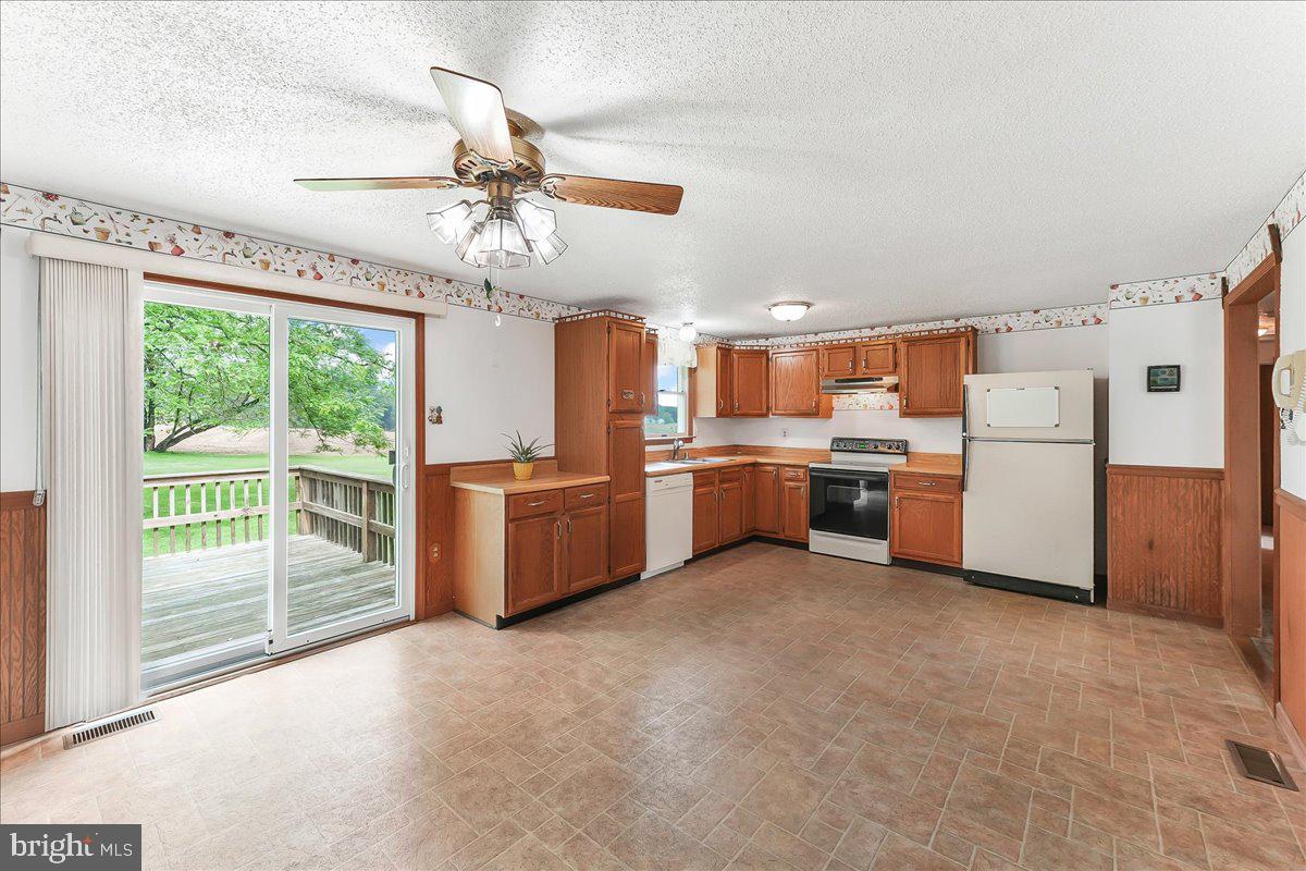 252 Althouse Road Cochranville, PA 19330 - Photo 9 of 28 a kitchen with stainless steel appliances a refrigerator a sink dishwasher a oven with white cabinets and wooden floor