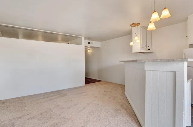 an empty room and a bathroom with a sink