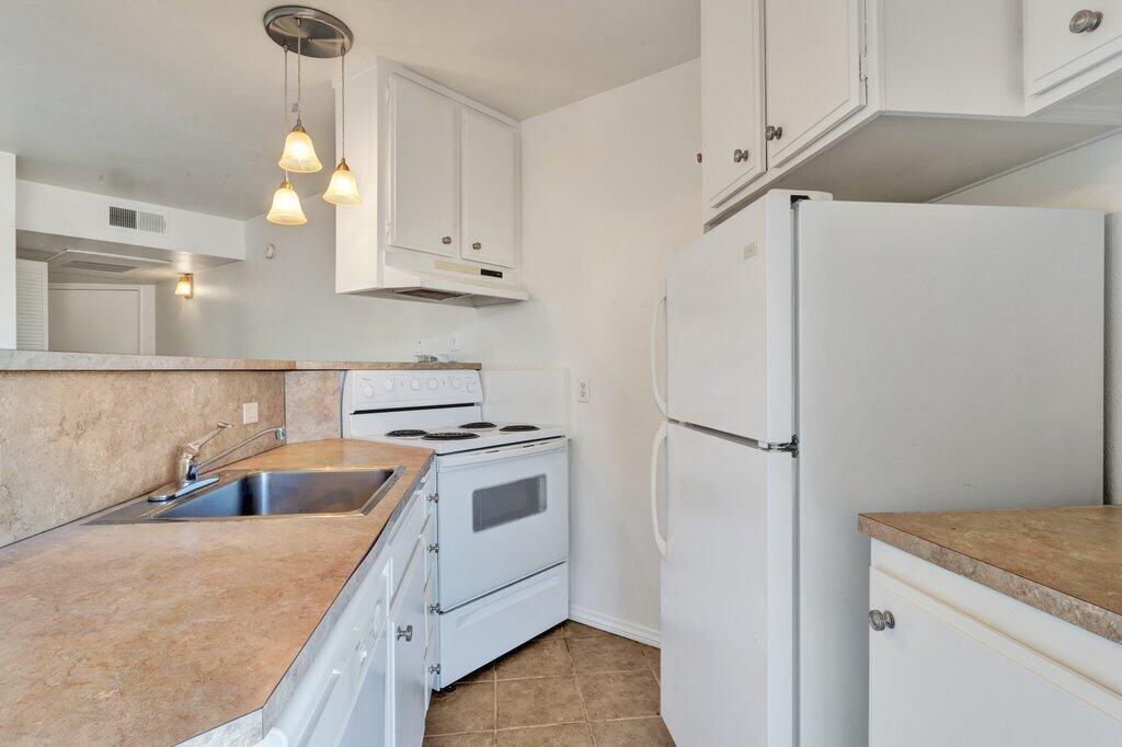 5300 East Waverly Drive, Unit 4209 Palm Springs, CA 92264 - Photo 5 of 13 a kitchen with stainless steel appliances granite countertop a sink a stove and a refrigerator