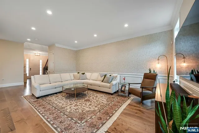 a kitchen with stainless steel appliances granite countertop a stove a refrigerator a oven a sink a dining table and chairs with wooden floor