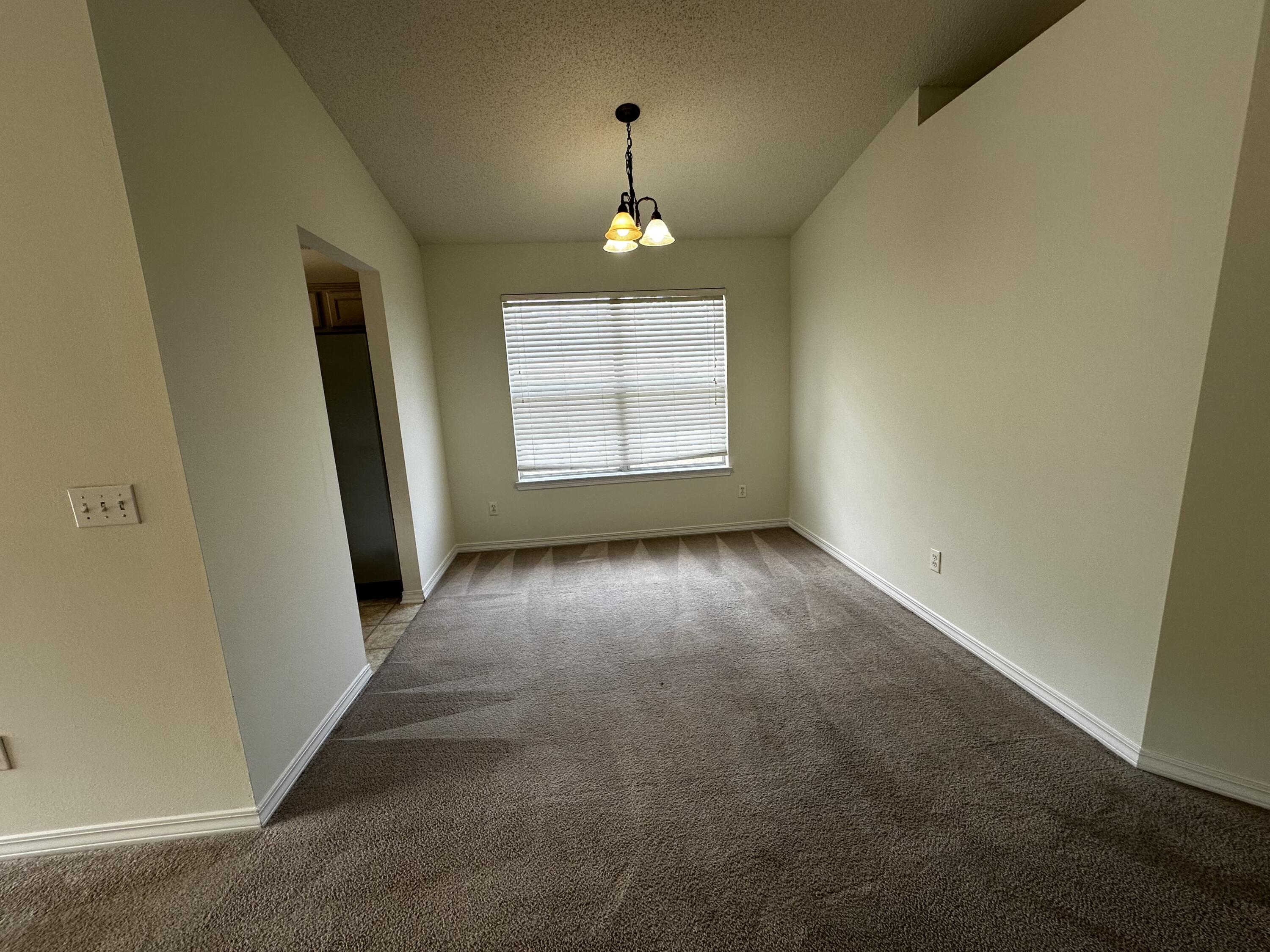 136 Sandstone Trail Crestview, FL 32539 - Photo 14 of 17 an empty room with windows and chandelier