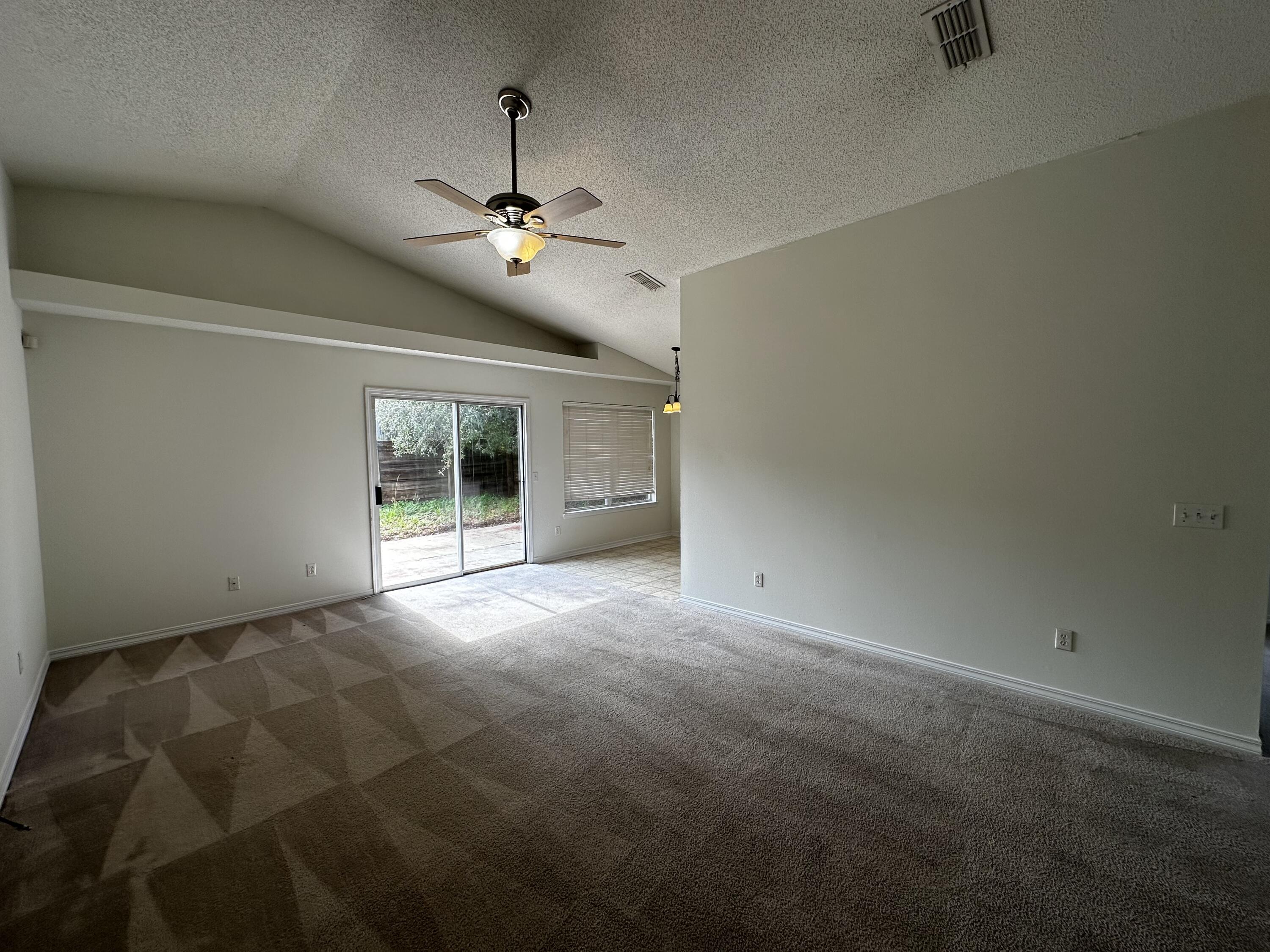 136 Sandstone Trail Crestview, FL 32539 - Photo 15 of 17 an empty room with chandelier fan and windows