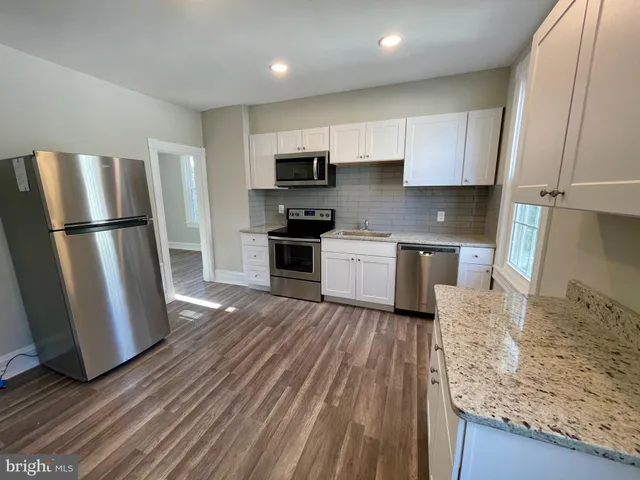 a kitchen with stainless steel appliances granite countertop a refrigerator stove a sink and dishwasher