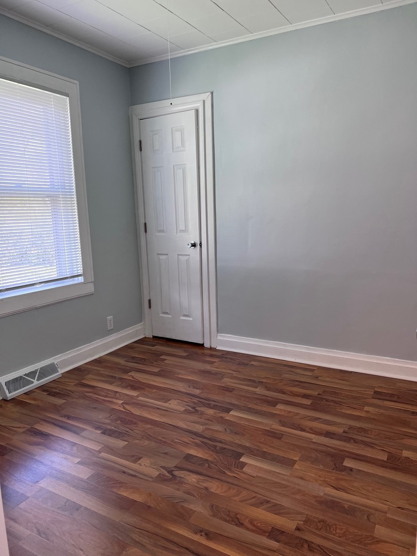 184 Waubansee Road Riverside, IL 60546 - Photo 12 of 38 a view of an empty room with wooden floor and a window
