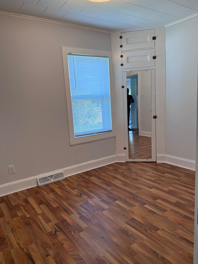 184 Waubansee Road Riverside, IL 60546 - Photo 23 of 38 a view of an empty room with wooden floor and a window
